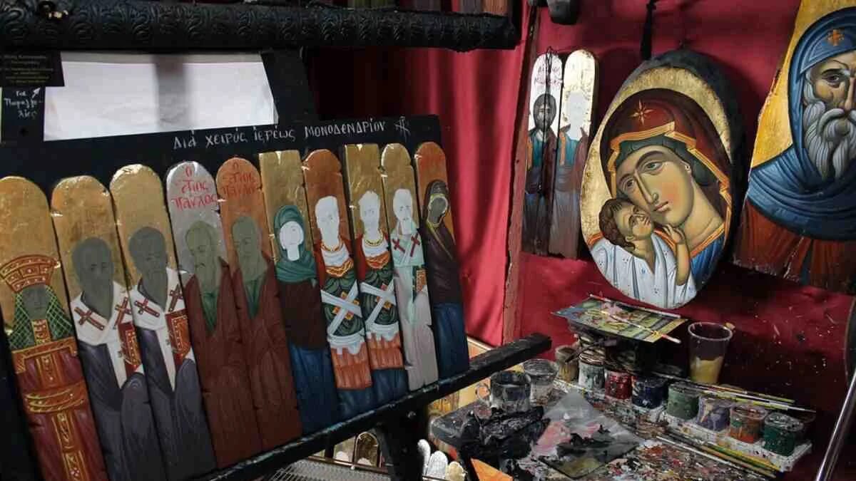 Im Atelier stehen farbenfrohe Heiligenbilder auf Holztafeln neben einer goldenen Marienikone mit dem Jesuskind.
