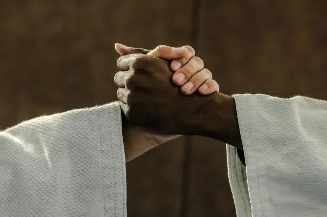 Zwei Judoka halten sich im Training fest und üben einen kraftvollen Griff, wie er in der Parabel vom einarmigen Jungen entscheidend ist.