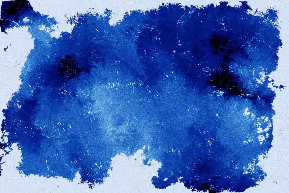 Kräftige blaue Farbfläche mit spürbaren Spritzern und Körnung, die an kühle Schatten erinnert und das Farbphänomen Blau nach Johann Wolfgang von Goethe spürbar macht.